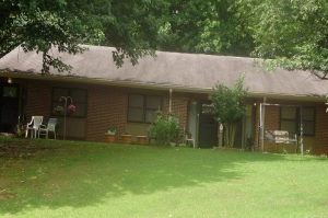 Shows a front image of the front of a small brick house