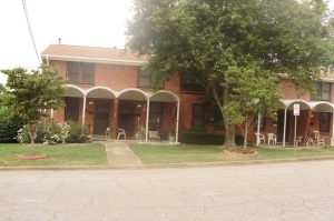 Shows several of the front entrances to a two story brick row house style building